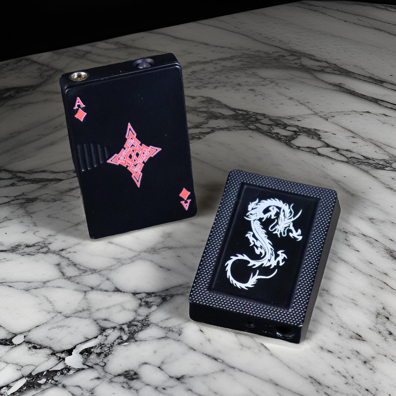 Ace Diamond lighter with a sleek black design featuring a bold red diamond pattern on the front, placed elegantly on a marble surface.