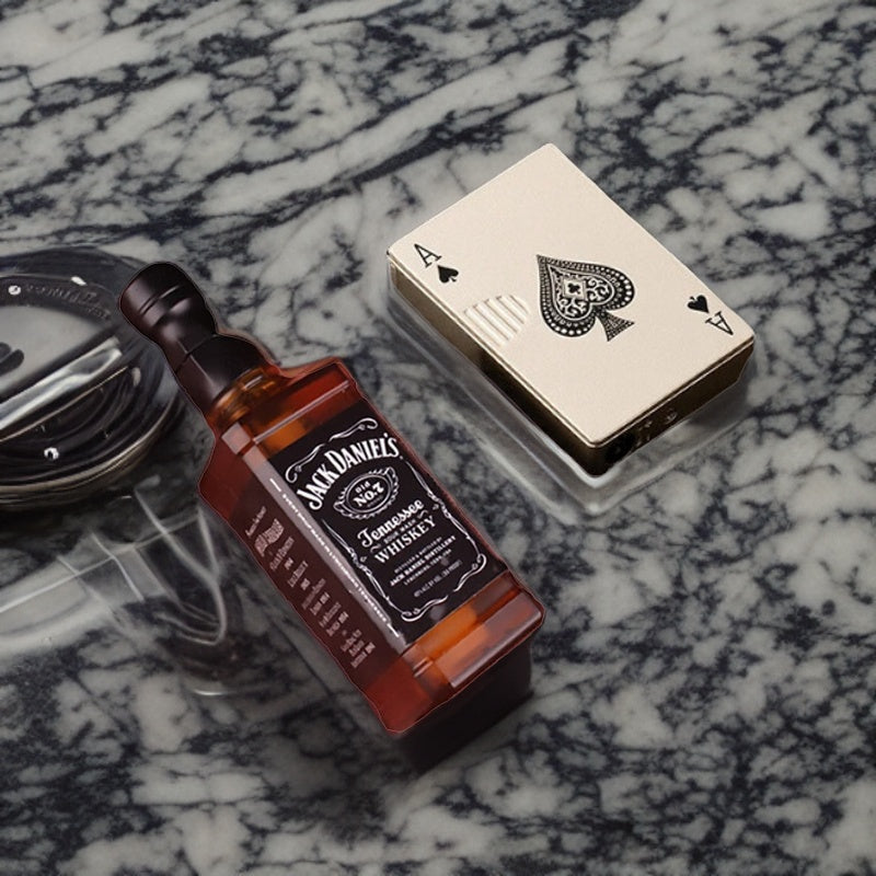 Ace of spades playing card lighter and miniature Jack Daniels whiskey bottle, elegantly displayed on a marble surface.