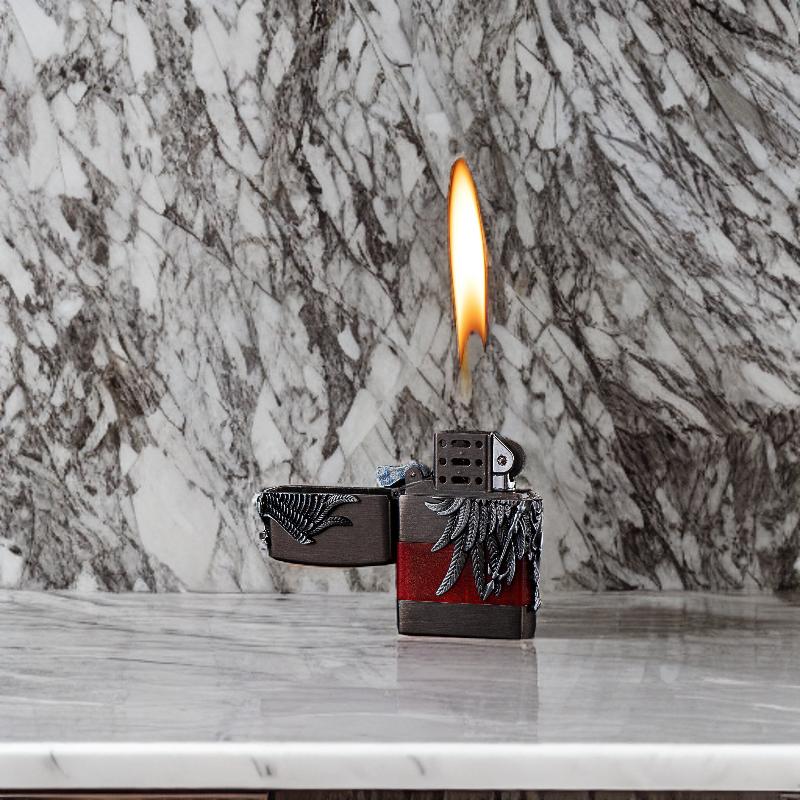 Angel of Flame lighter with flame lit, highlighting its artistic craftsmanship.