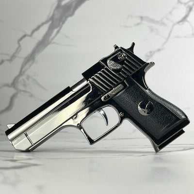 Chrome and black Beretta-style refillable torch lighter with realistic pistol design, shown flat on a marble background.