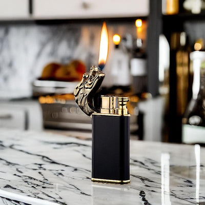 Elegant dragon-themed lighter emitting a vibrant orange flame, displayed on a marble counter for a luxurious feel.