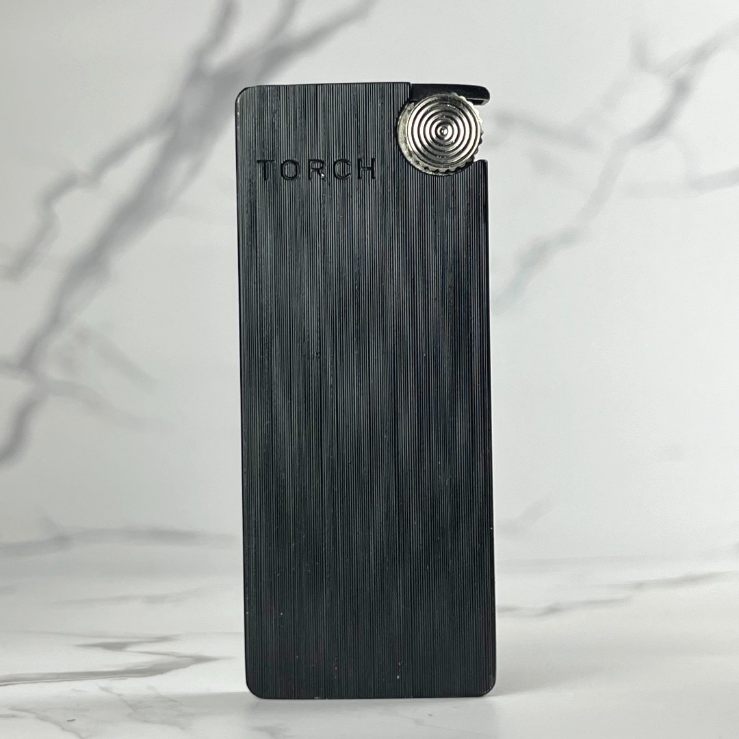 Matte black slim torch lighter with vertical etching and silver ignition wheel.