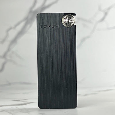 Matte black slim torch lighter with vertical etching and silver ignition wheel.