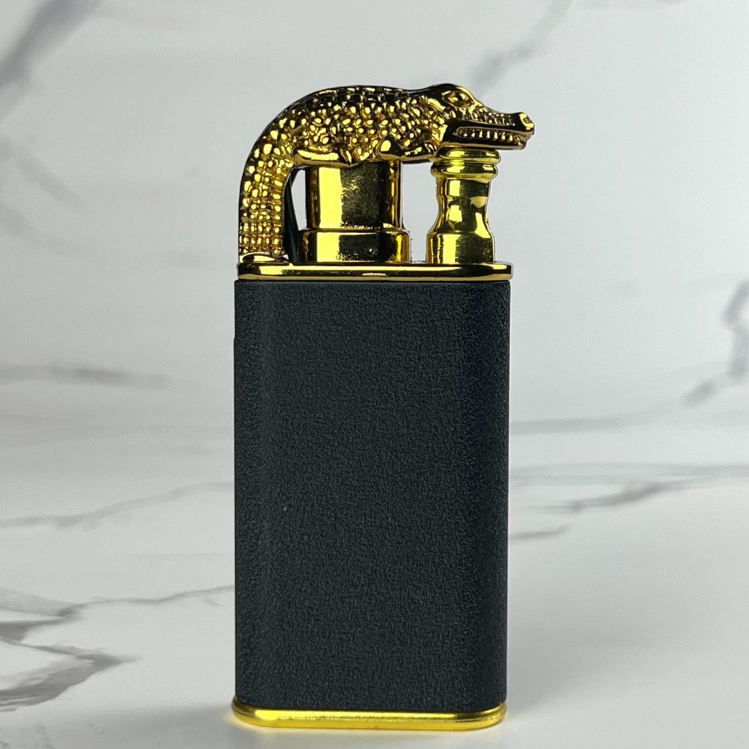 Black and gold crocodile-shaped torch lighter standing upright.