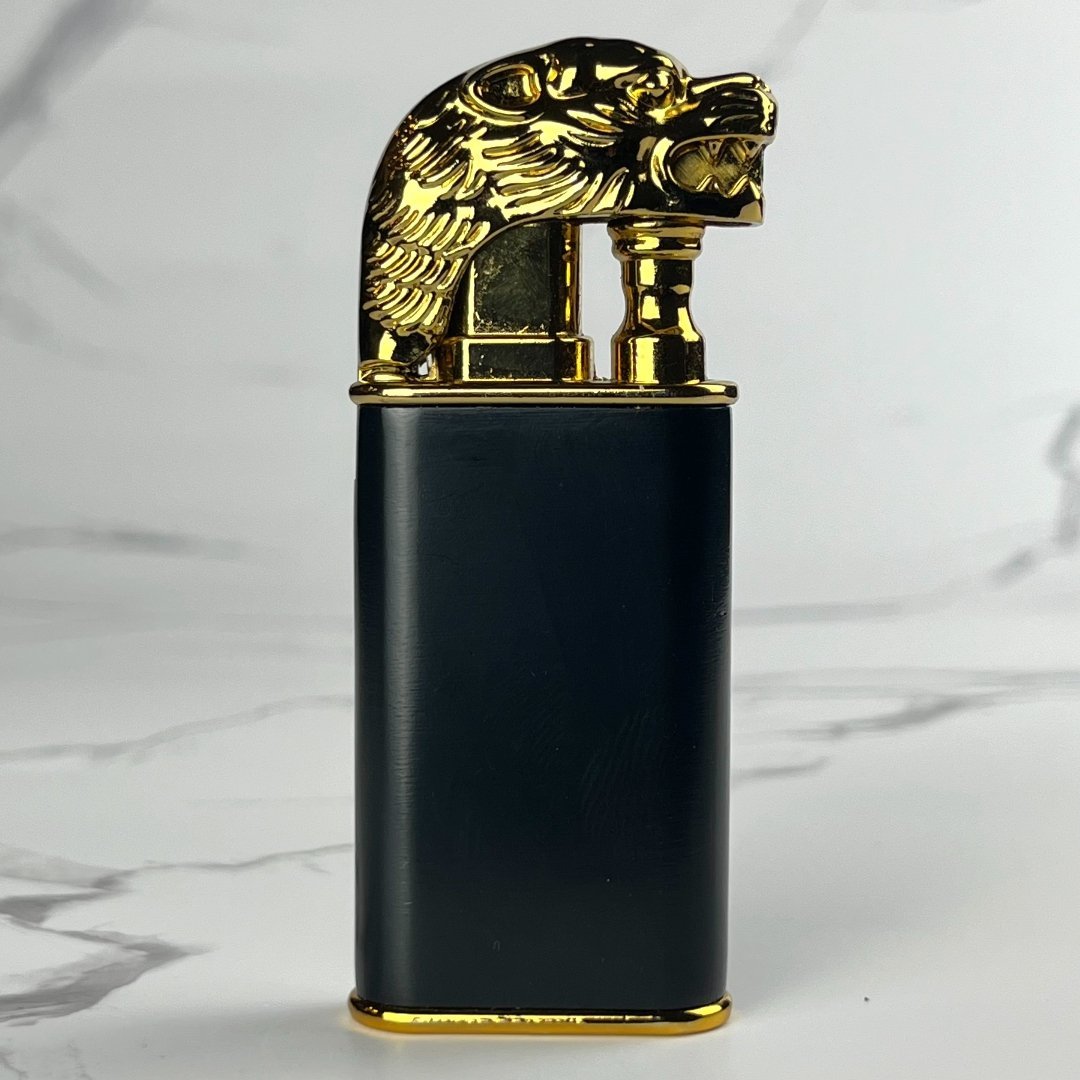 Black lighter featuring a detailed gold lion head as the lid.