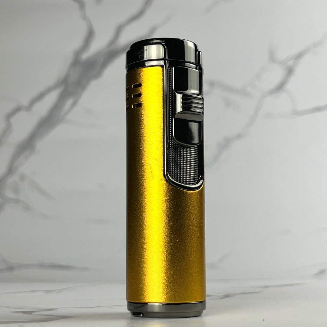 Sleek gold refillable torch lighter with black ignition switch and textured grip, standing on marble background.
