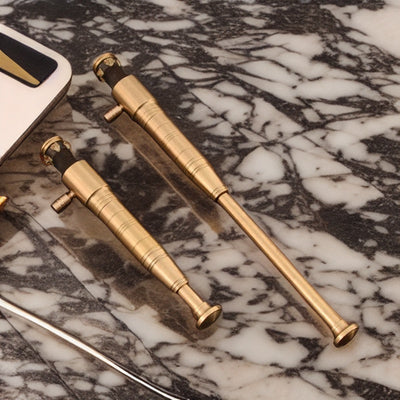 Premium gold-colored torch lighters with sleek, cylindrical design resting on a marble surface