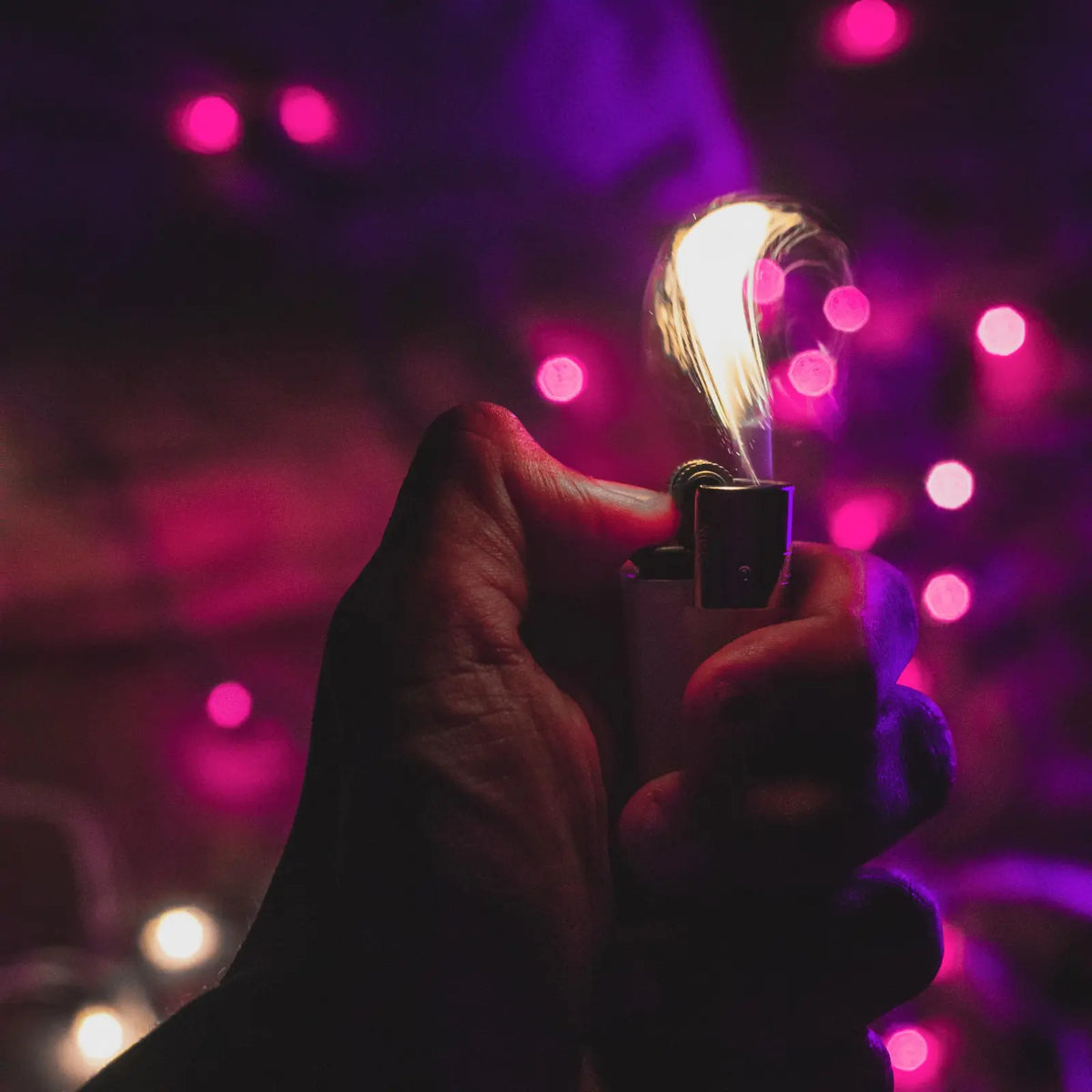 Refillable lighter ignited in hand with glowing purple background – mobile version for LighterLoungeCo