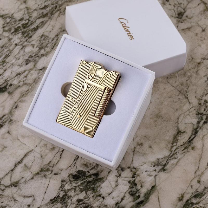 Elegant gold sanji lighter with an intricate design, presented in a premium white gift box, set on a marble background.