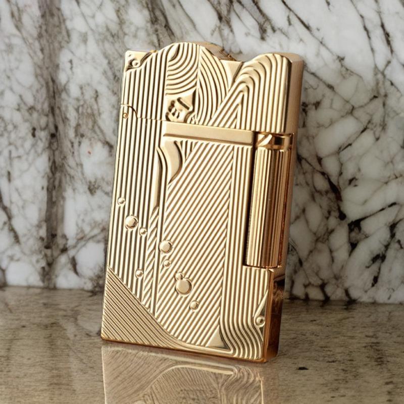 Close-up view of a gold sanji lighter showcasing its luxurious, textured design against a marble background.