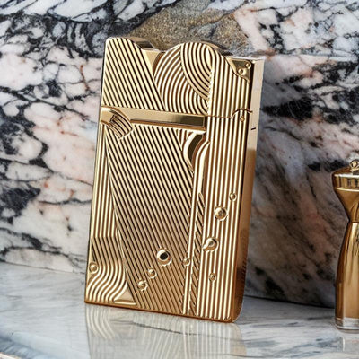 Luxurious gold sanji lighter with intricate patterns, standing upright on a marble surface.