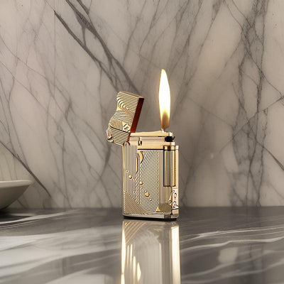 Gold sanji lighter with an intricate design, lit with a bright flame, standing on a polished marble surface.