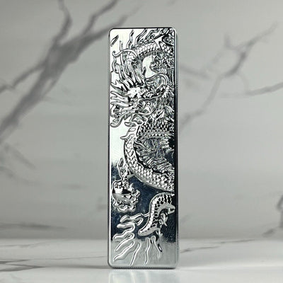 Sleek silver bar lighter featuring an intricate engraved dragon design on a reflective chrome finish.