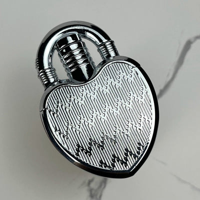 Polished silver heart-shaped lock lighter featuring a detailed etched surface.

